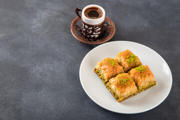 Traditional pistachio baklava with Turkish coffee on black background,top view