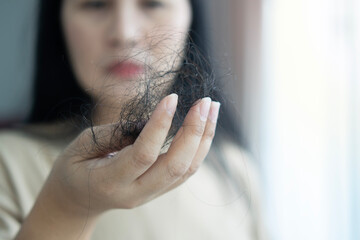 Naklejka premium Attractive Asian woman serious about her hair and presentation hair loss problem