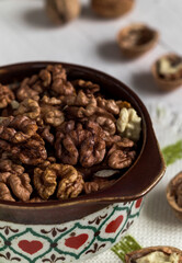 Bowl with peeled walnuts on a white background.