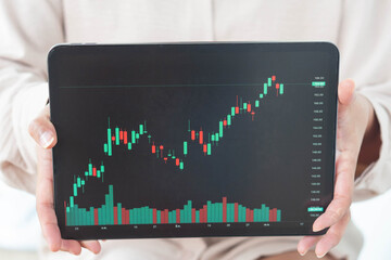 Business woman hand holding digital tablet computer with graph of Binary option for trading...