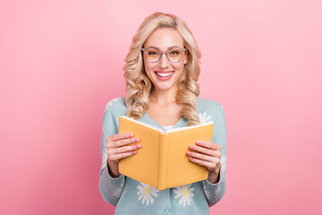 Portrait of gorgeous positive person toothy smile hold opened book isolated on oink color background