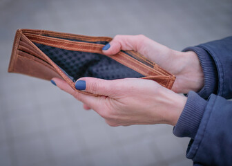 Woman holding empty brown wallet