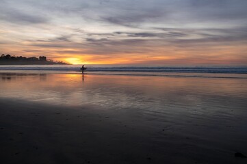 the person is in the water with a surfboard near the ocean