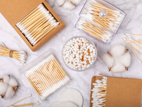 Cotton swabs in craft packaging on a white marble background. Bamboo cotton buds. Means for hygiene of ears. Eco-friendly materials.Hygienic cotton ear buds.
