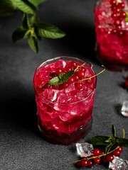 Vertical shot of cocktail with red currant and mint