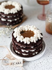 Chocolate cake with white frosting on a white plate