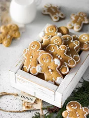 Fotobehang Vertical shot of a wooden box with homemade cute Christmas gingerbread cookies © Masha Svejenceva/Wirestock Creators