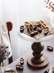 Deurstickers Vertical shot of a decorative stand with chocolate nut sweets © Masha Svejenceva/Wirestock Creators