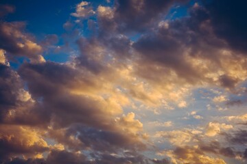 Dramatic shot of storm clouds illuminated by disappearing rays at sunset