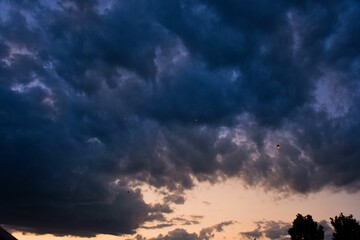 Naklejka na ściany i meble Dramatic shot of dark clouds before storm, at the sunset