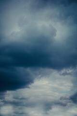 Naklejka na ściany i meble Vertical shot of large clouds in a dark stormy sky