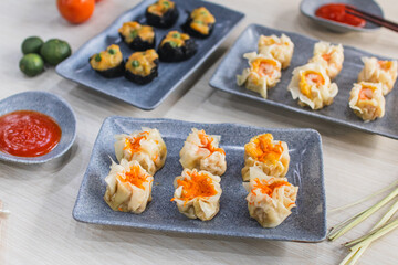 Assorted dim sum appetizers on wooden table background. Set of Chinese food for share. Asian...