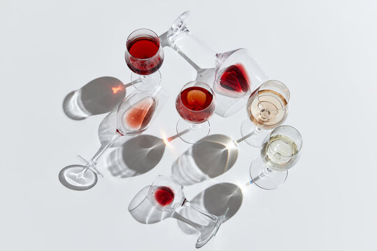 Romantic drink. Glasses filled with red, white and rose wine against white background. Tasting. Concept of taste, alcohol, wine degustation, variety, winemaking. Flat lay design