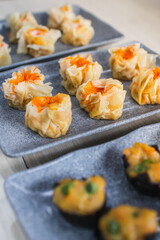 Assorted dim sum appetizers on wooden table background. Set of Chinese food for share. Asian buffet. Traditional Chinese dim sum food. Top view. Different Chinese dumplings on table