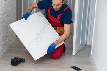 Installing ceramic floor tiles - measuring and cutting the pieces, closeup