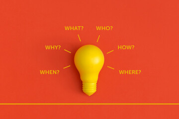 Light bulb on yellow background. Inspiration and creative idea concept. Who, why, how, what, when and where questions.