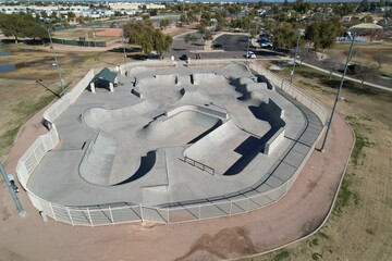 an empty skate park with ramps and trucks parked in it