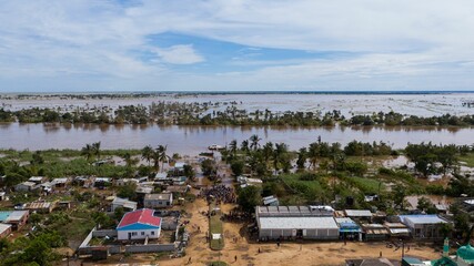 Big flood with trees and a village in the dirty waters in Africa