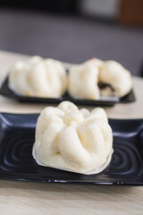 Chinese traditional steamed bun (Bakpao), served on plate on wooden background