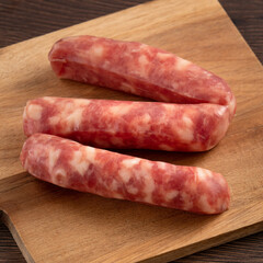 Raw Taiwanese sausage in garlic flavor in a plate on wooden table background.
