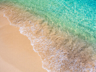 Calm beach scene. Movement of blue sea water and wave surf on clean sandy beach ocean, sea shore, coastline, summer vacation holiday background.