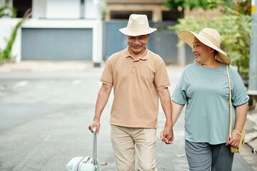 Excited senior couple wearing hats when going on vacation