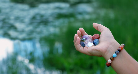 quartz minerals chakra set in hand, natural blurred background. Esoteric spiritual crystals...