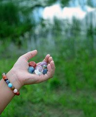 quartz minerals chakra set in hand, natural blurred background. Esoteric spiritual crystals...