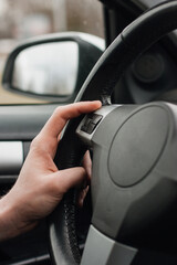 Drivers's hands on a left stearing,steering wheel of a car