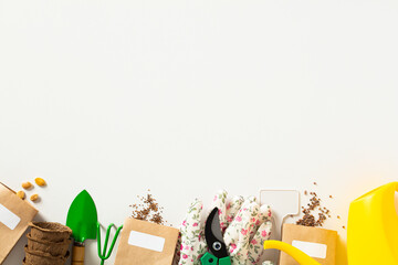 Frame from garden tools and seeds on a white background. Flat lay, top view.