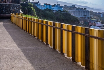 Farbige Metallbegrenzung zum Meer an einem Gehweg auf Teneriffa