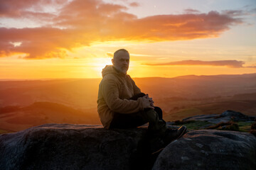 Bearded Man reaching the destination and on the top of mountain at sunrise or sunset on cold  day Travel Lifestyle concept The national park Pick District in England