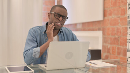 African Man having Toothache while Working on Laptop, infection