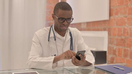 Young African Doctor Using Smartphone at Work 