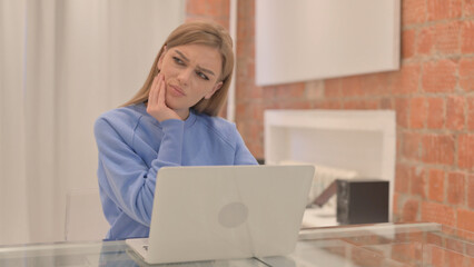 Young Woman having Toothache while Working on Laptop