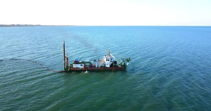 Sand dredging ship on the shore of the beach