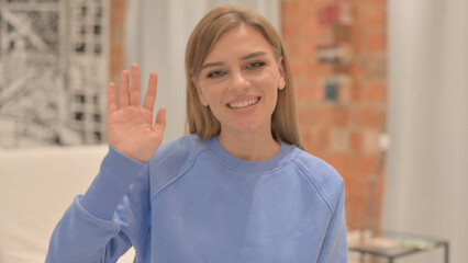 Portrait of Young Woman Waving at Camera 