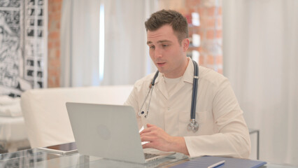Fototapeta na wymiar Online Video Chat by Male Doctor on Laptop in Clinic