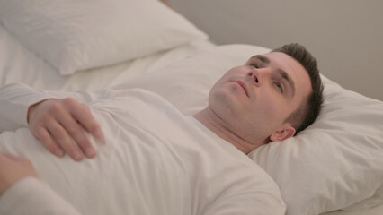 Brainstorming Young Man with Open Eyes Lying in Bed