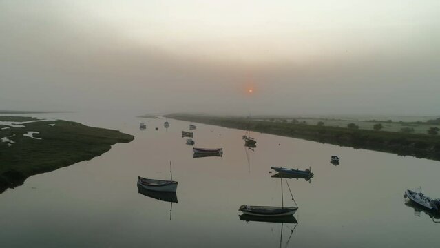 Slow Pullback Establishing Drone Shot of Burnham Overy Staithe Creek in Low Light Foggy Sunrise in North Norfolk UK