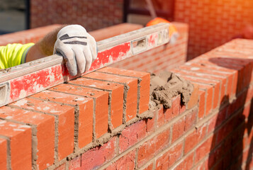 Bricklayers laying bricks on mortar