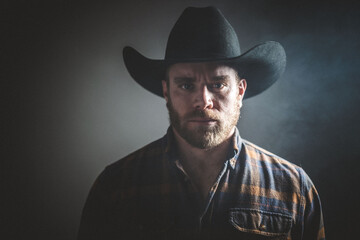 Rugged man in cowboy hat.  Studio session.