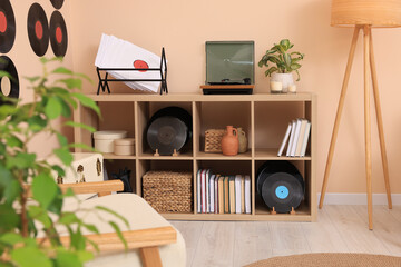 Vinyl record player on wooden shelving unit indoors