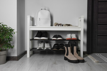 Shoe storage bench near white wall in hallway. Interior design