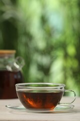 Cup of aromatic tea on white table outdoors. Space for text
