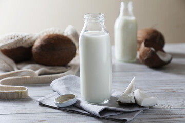 Coconut milk and nuts on white wooden table
