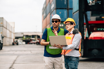 Team Engineer and worker wear safety uniform check control loading freight cargo container use computer laptop at commercial dock warehouse,transportation import,export logistic industrial service