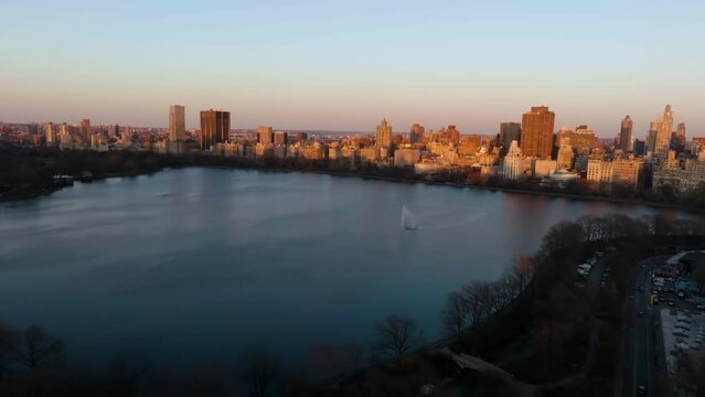 Aerial overview of the Central park reservoir and the sunlit cityscape of Upper East Side, Manhattan, NY