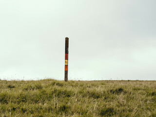 Fototapeta na wymiar Wayfinding directional pole on farm meadow.