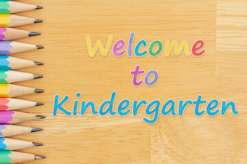 Welcome to Kindergarten message with pastel color pencils on wood desk